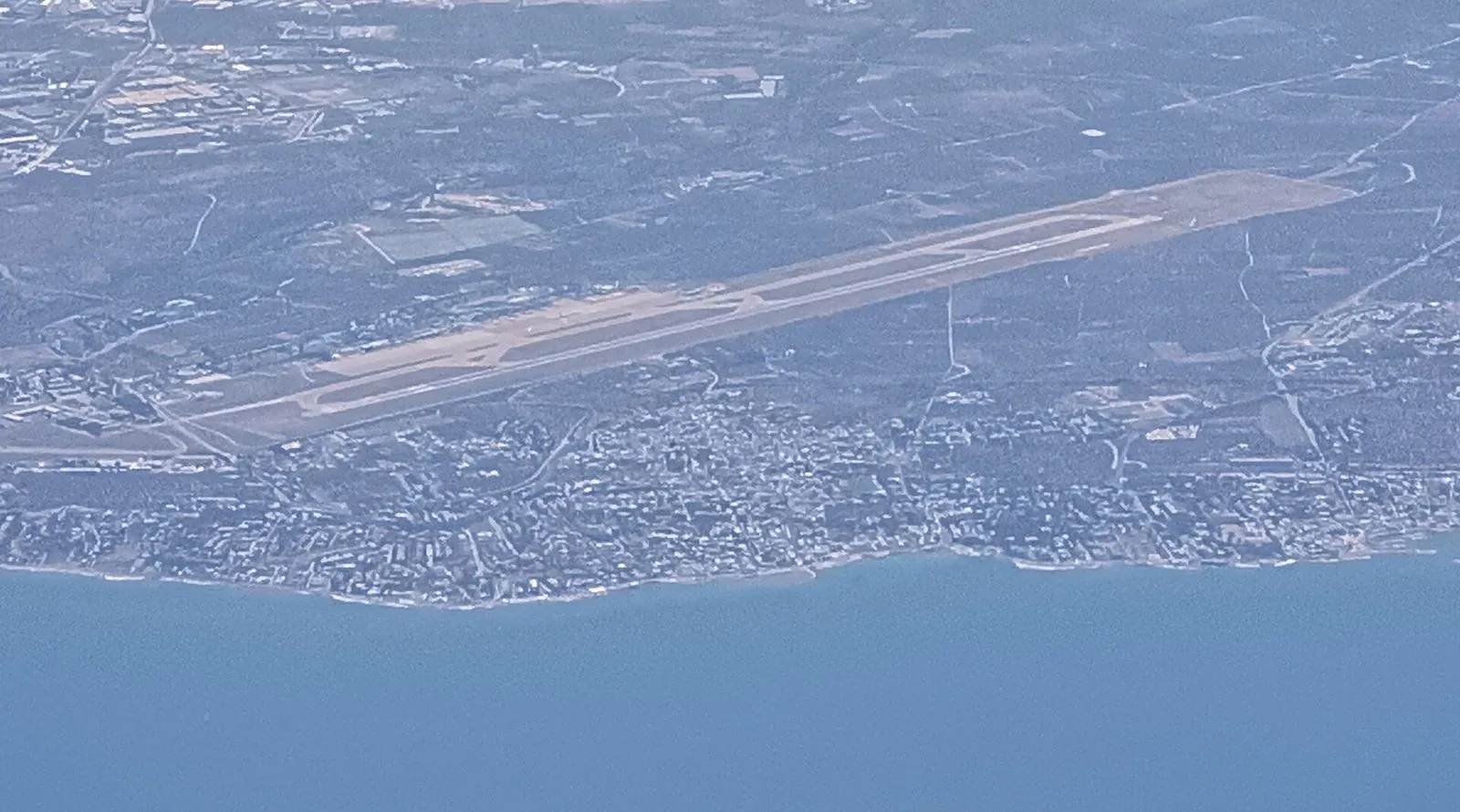 Veduta aerea della pista dell'aeroporto di Bari con i quartieri costieri di Palese e il mare Adriatico in primo piano