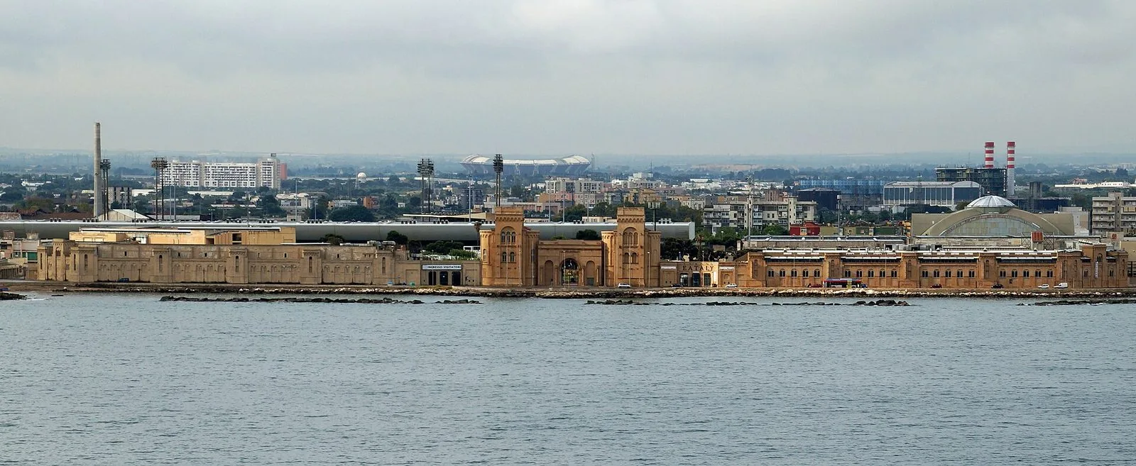 Il quartiere fieristico della Fiera del Levante visto dal mare: i padiglioni color sabbia e l'ingresso monumentale con le due torri affacciati sul lungomare di Bari